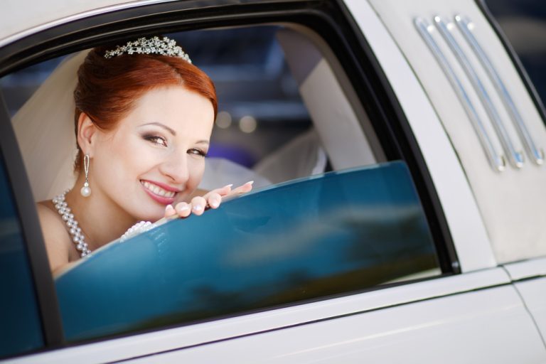 Young,Smiling,Caucasian,Bride,In,White,Limo.