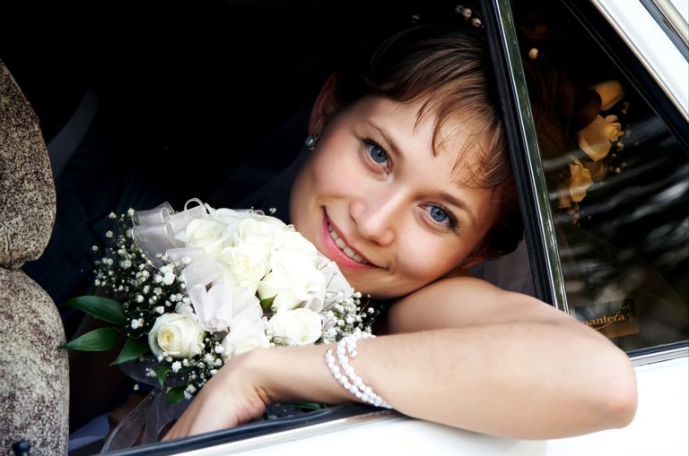 Beautiful,Bride,Is,Smiling,In,A,Car