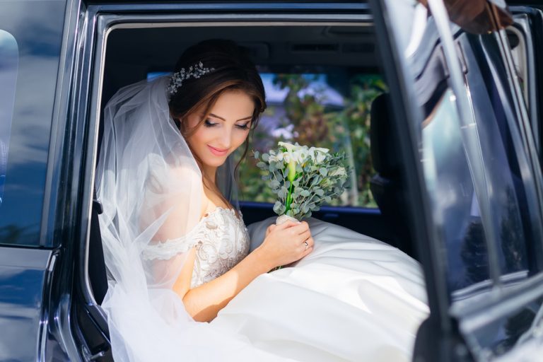 Cute,Bride,Sits,In,A,Black,Car,On,The,Wedding